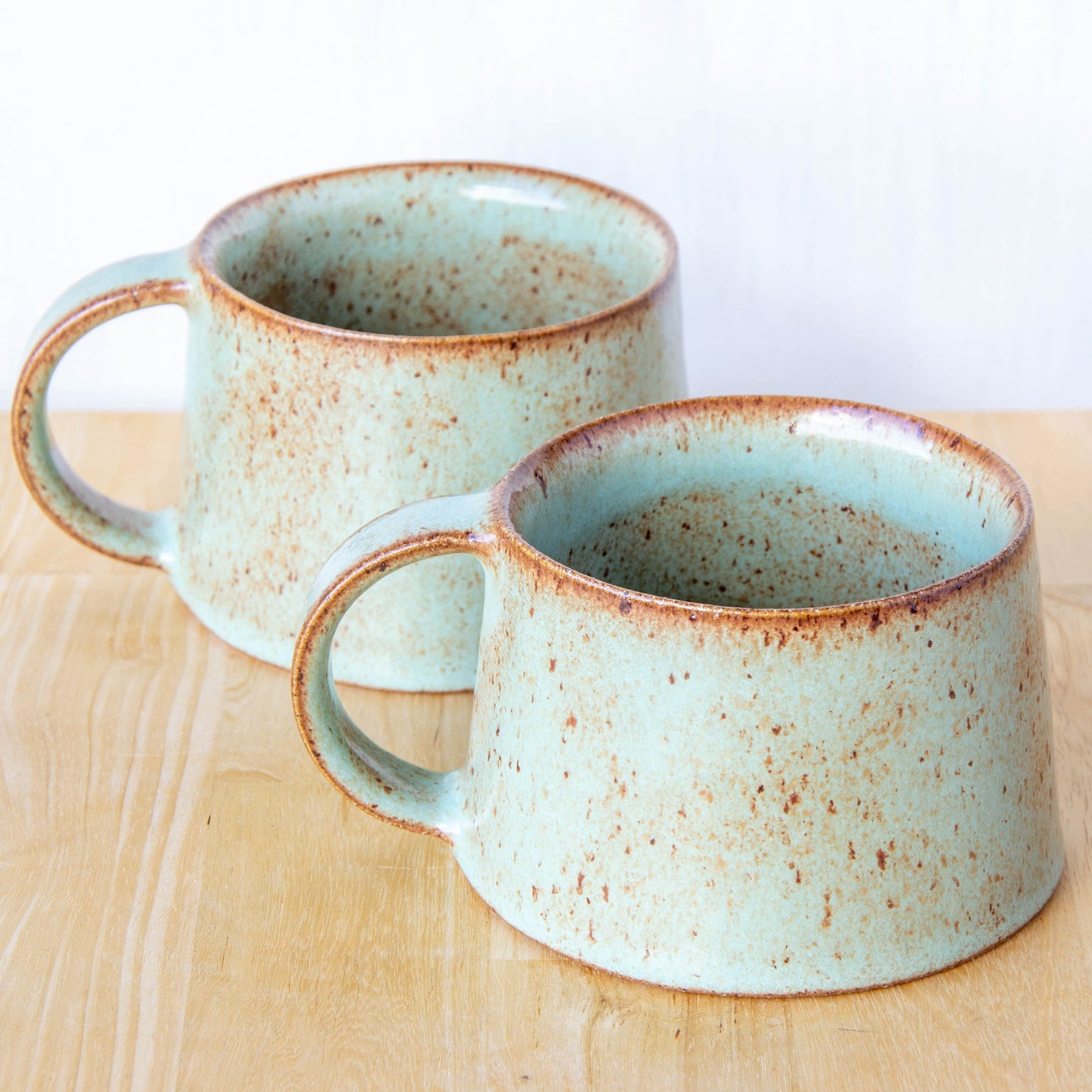 Handmade mug by Land and Line Ceramics New Zealand made pottery green mug tapered mug with rustic wabi-sabi style glaze