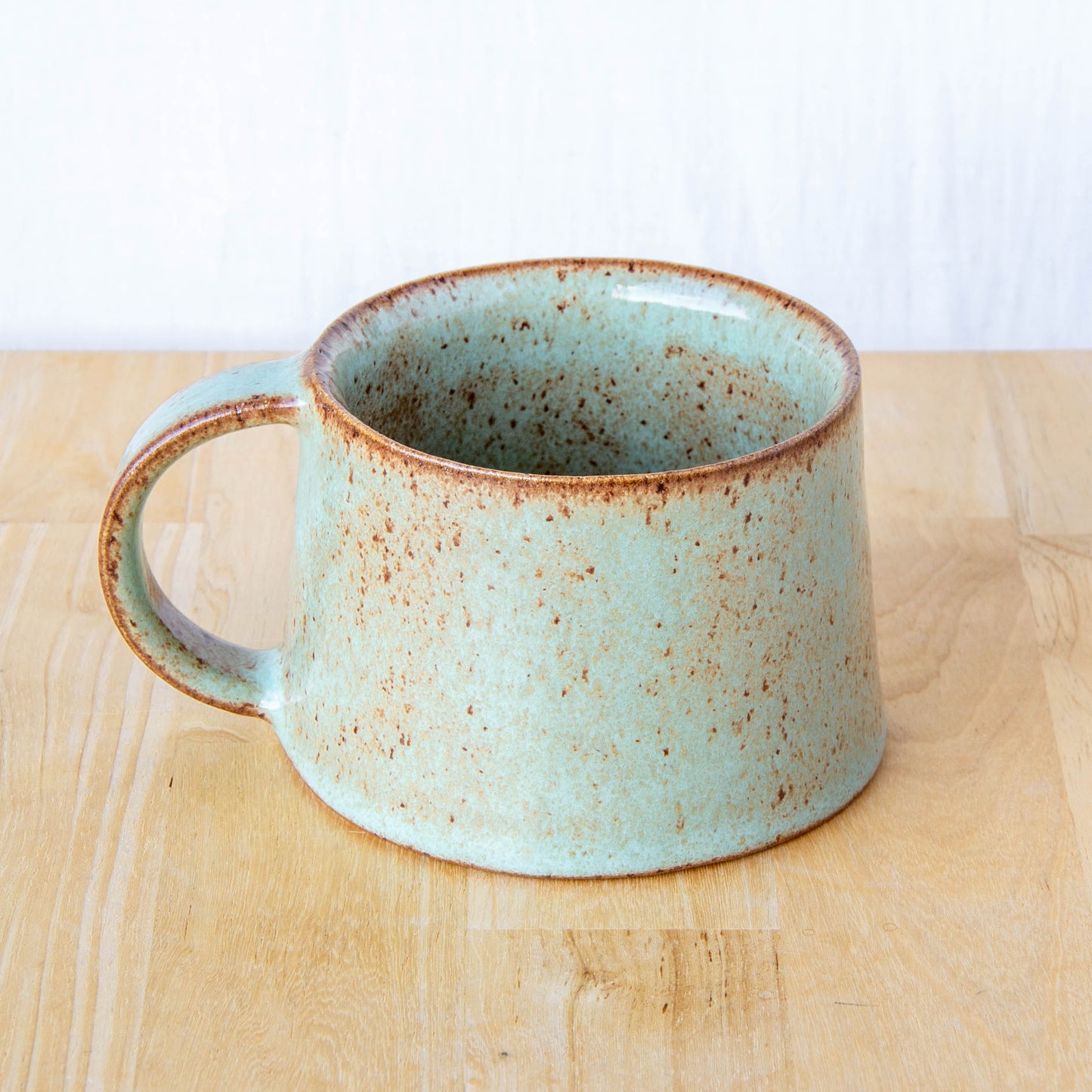 Handmade mug by Land and Line Ceramics New Zealand made pottery. Green mug tapered mug with rustic wabi-sabi style glaze