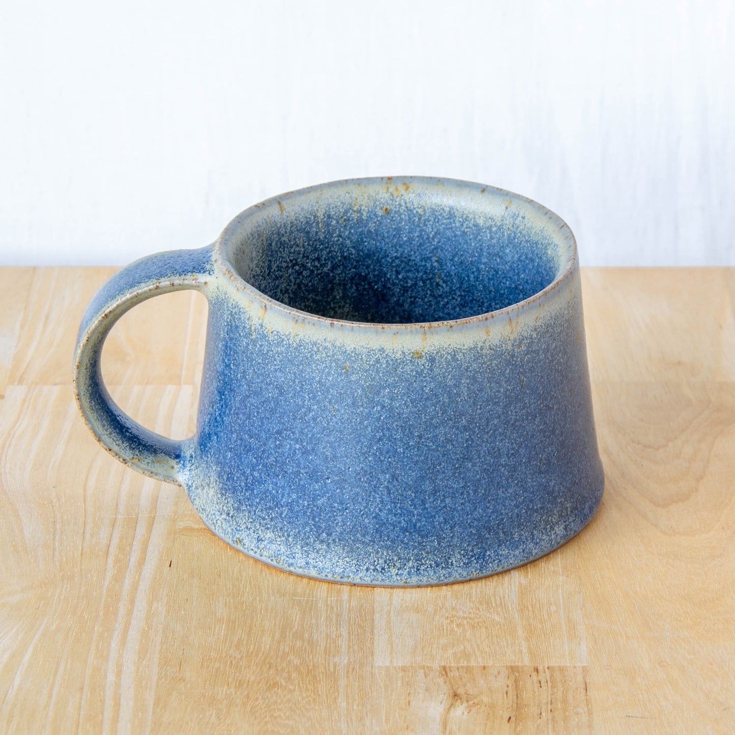 Handmade mug by Land and Line Ceramics New Zealand made pottery blue mug. tapered mug with rustic wabi-sabi style glaze