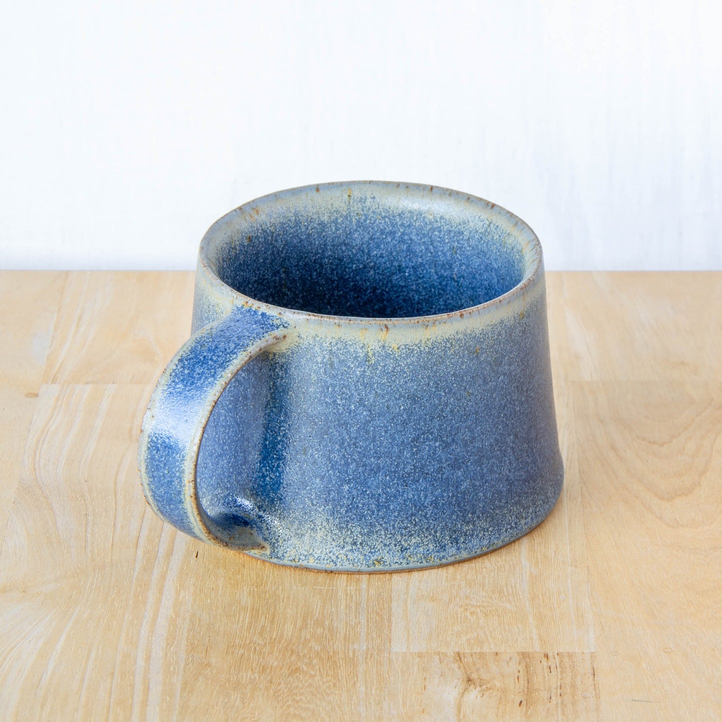 Handmade mug by Land and Line Ceramics New Zealand made pottery blue mug. tapered mug with rustic wabi-sabi style glaze