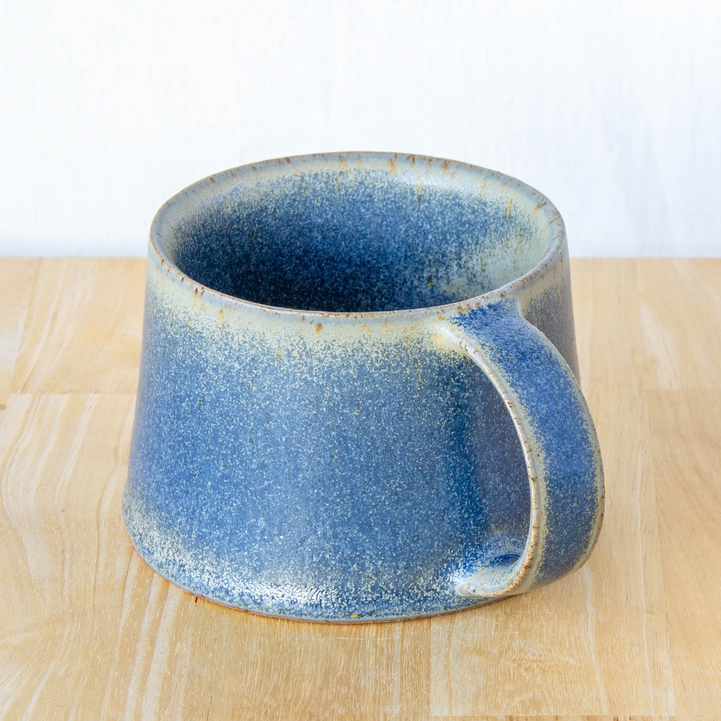 Handmade mug by Land and Line Ceramics New Zealand made pottery blue mug. tapered mug with rustic wabi-sabi style glaze