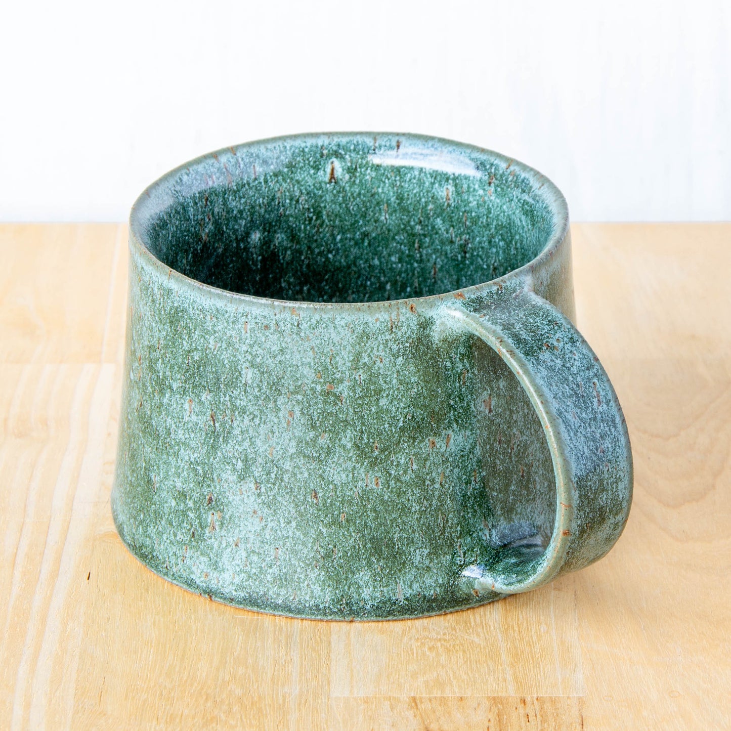 Handmade mug by Land and Line Ceramics New Zealand made pottery greenstone mug. tapered mug with rustic wabi-sabi style glaze