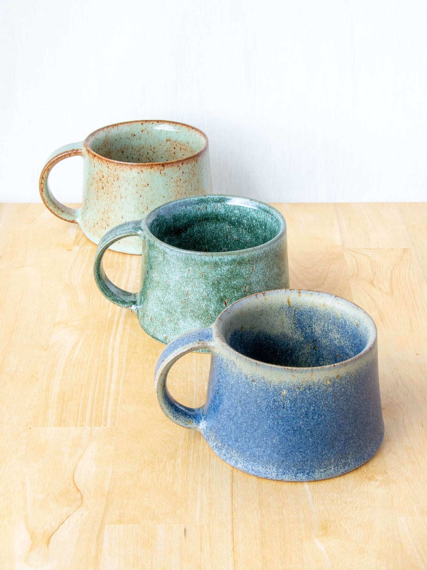Handmade mug by Land and Line Ceramics New Zealand made pottery green mug tapered mug with rustic wabi-sabi style glaze