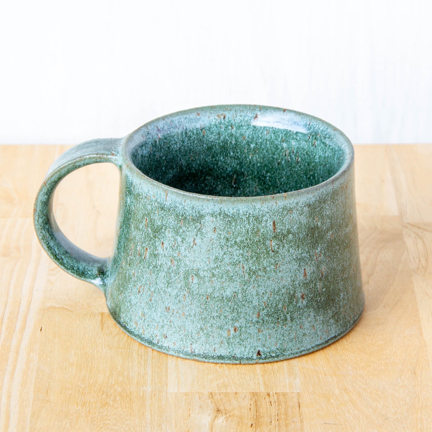Handmade mug by Land and Line Ceramics New Zealand made pottery greenstone mug. tapered mug with rustic wabi-sabi style glaze