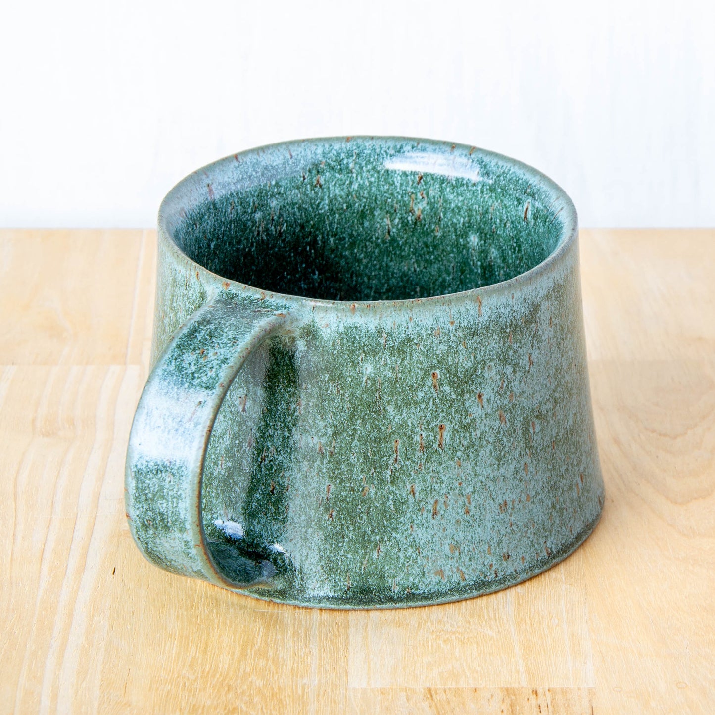 Handmade mug by Land and Line Ceramics New Zealand made pottery greenstone mug. tapered mug with rustic wabi-sabi style glaze