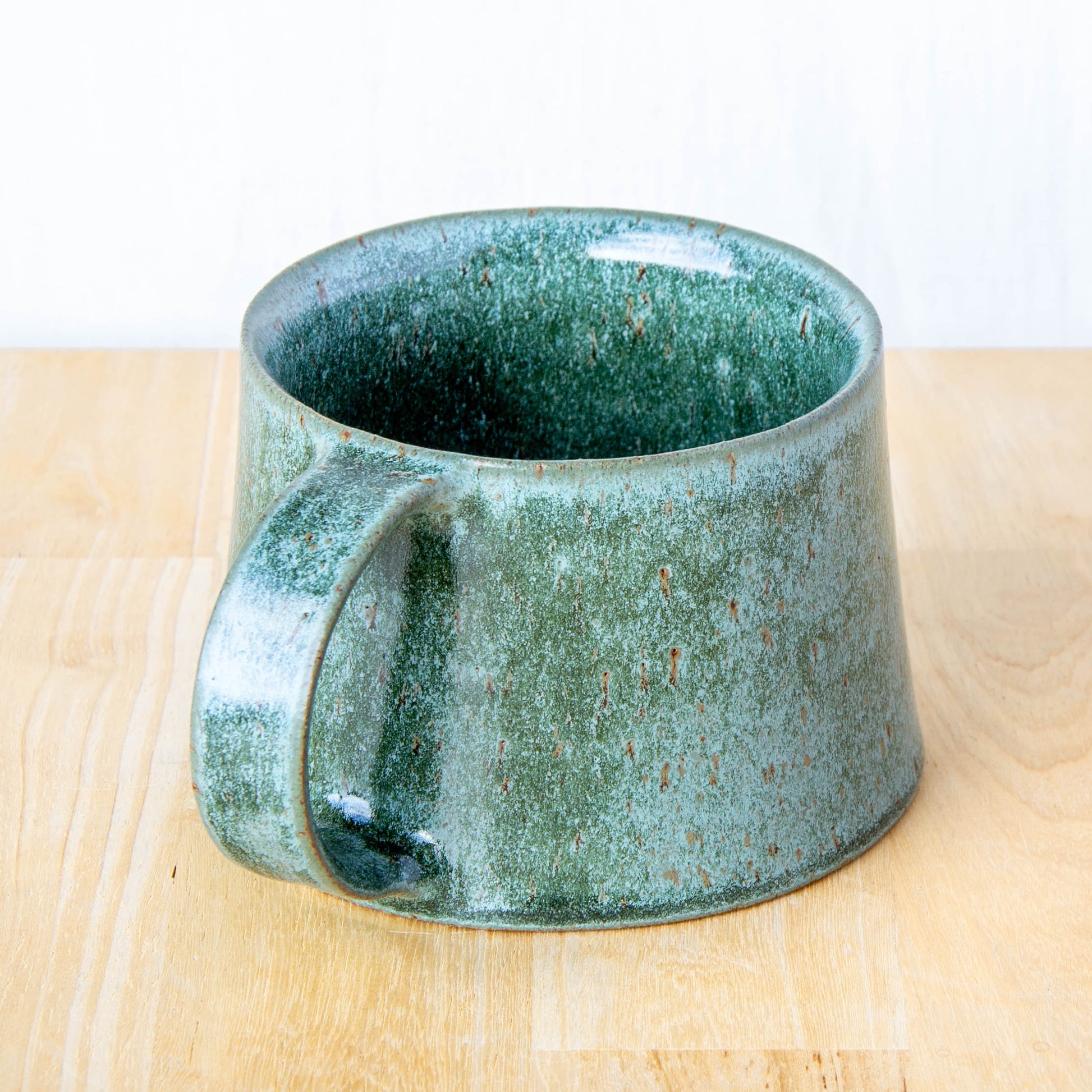 Handmade mug by Land and Line Ceramics New Zealand made pottery greenstone mug. tapered mug with rustic wabi-sabi style glaze