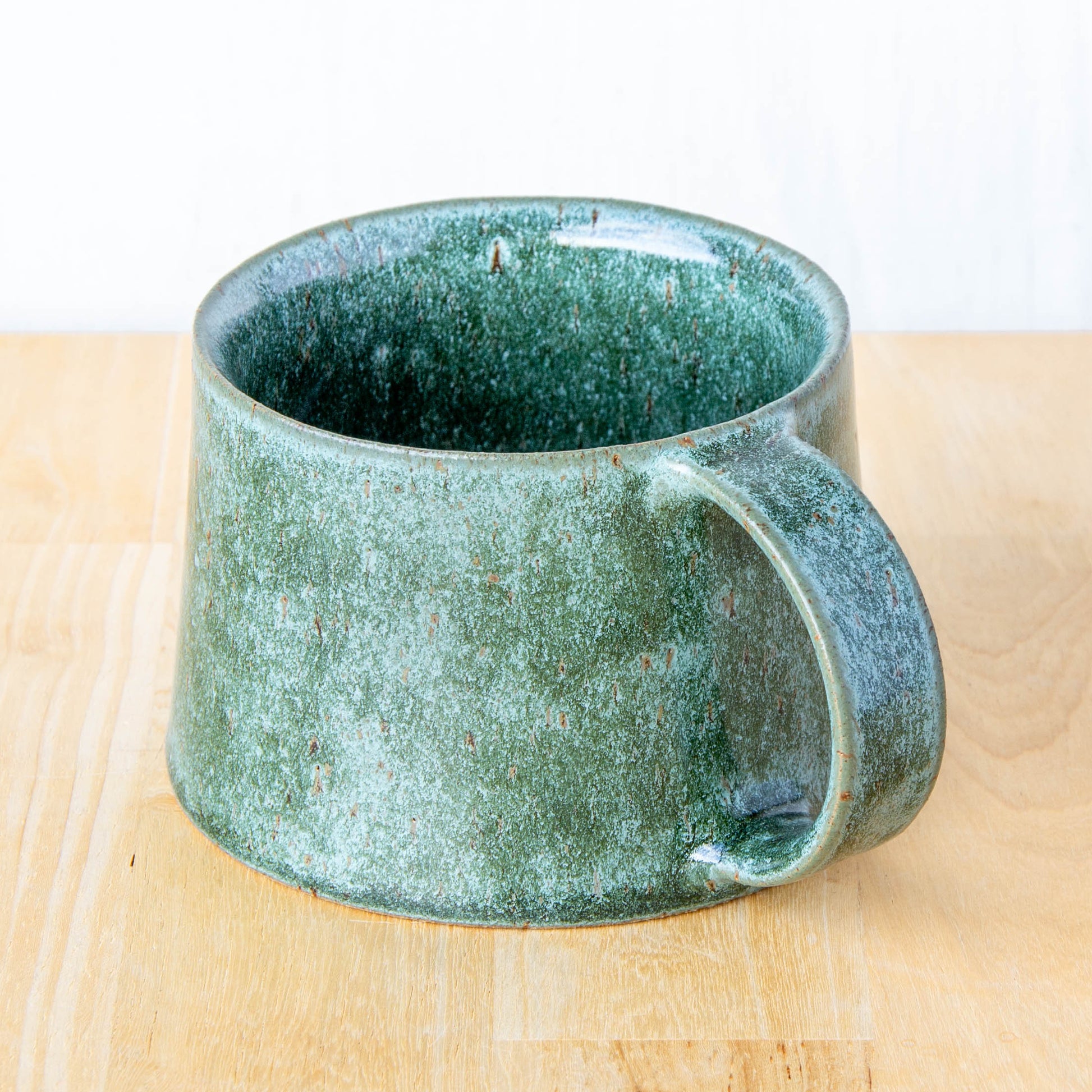 Handmade mug by Land and Line Ceramics New Zealand made pottery greenstone mug. tapered mug with rustic wabi-sabi style glaze