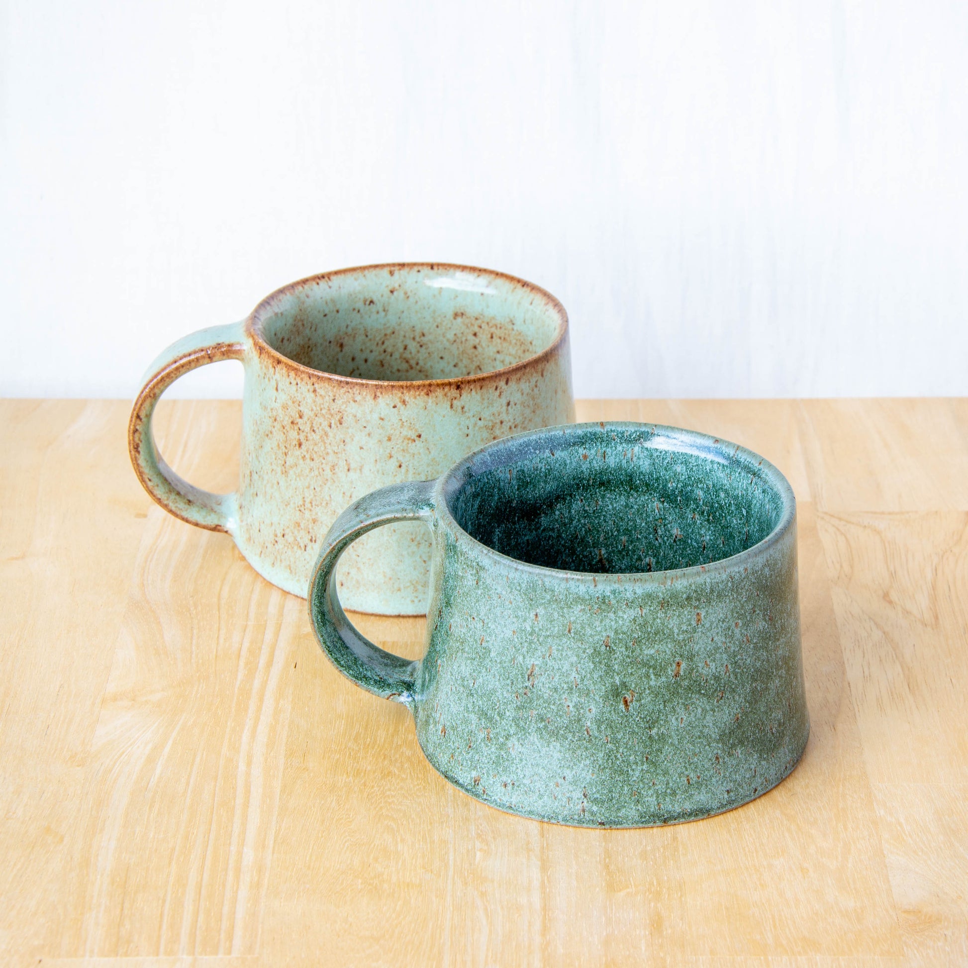 Handmade mug by Land and Line Ceramics New Zealand made pottery green mug tapered mug with rustic wabi-sabi style glaze