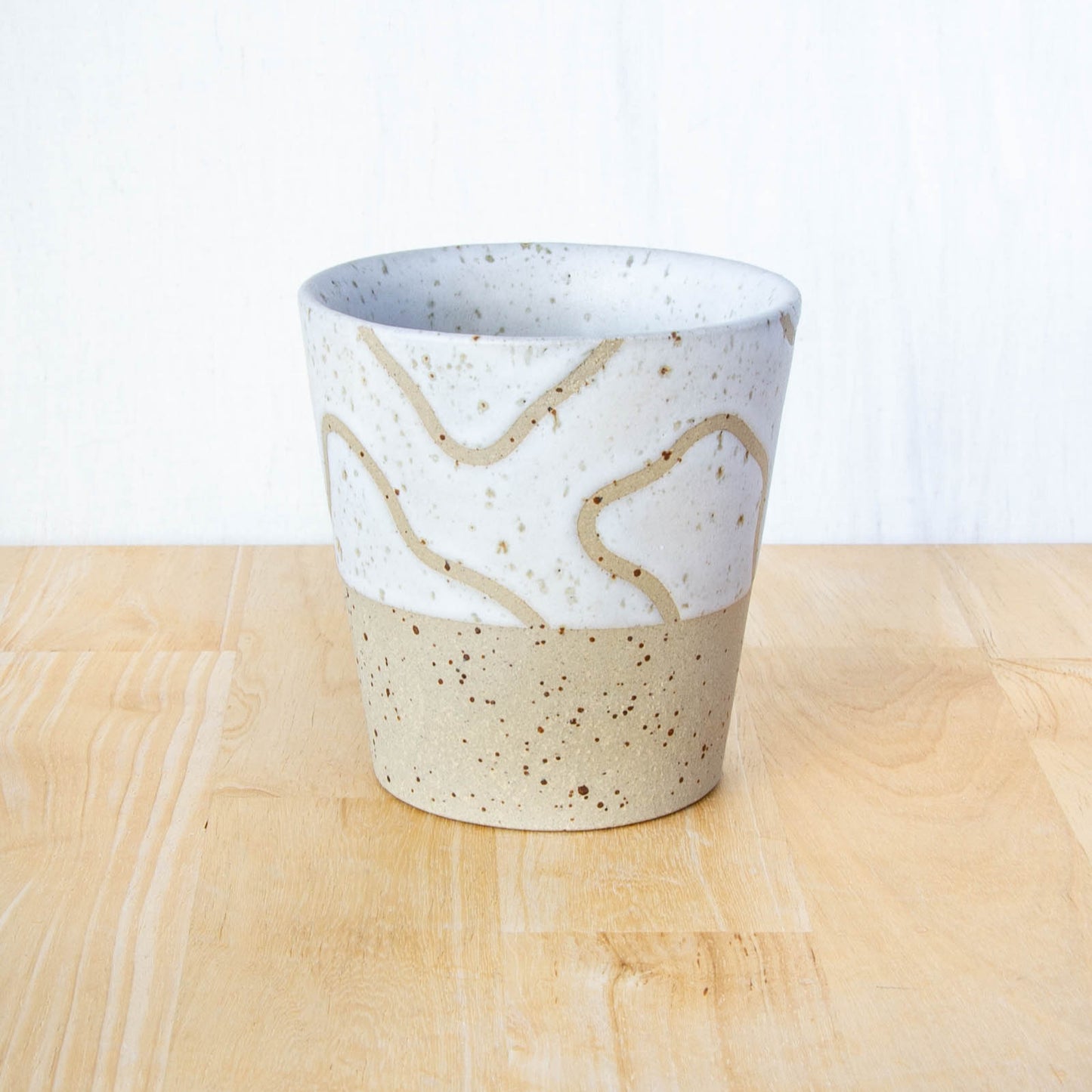 Handmade ceramic coffee tumbler by Land and Line Ceramics with abstract topographic line art design