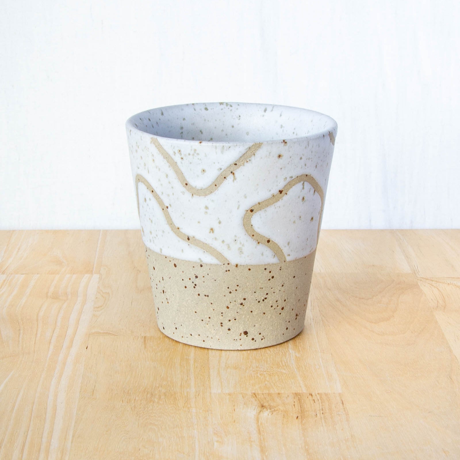 Handmade ceramic coffee tumbler by Land and Line Ceramics with abstract topographic line art design