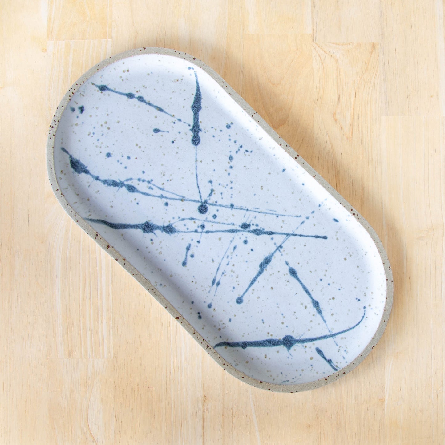 rounded oblong pill shaped plate handmade cheese board platter rustic white and blue glaze splatter design
