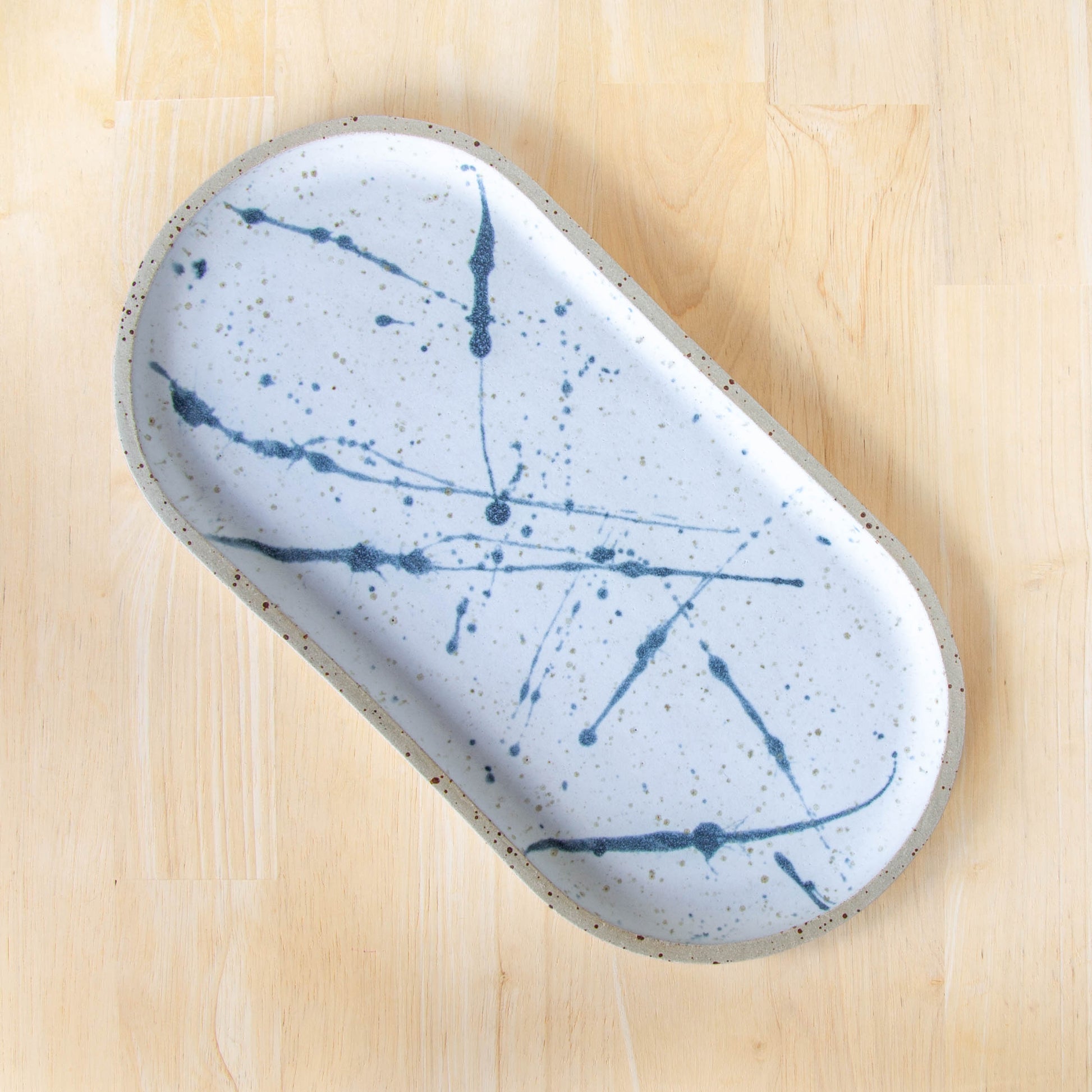 rounded oblong pill shaped plate handmade cheese board platter rustic white and blue glaze splatter design